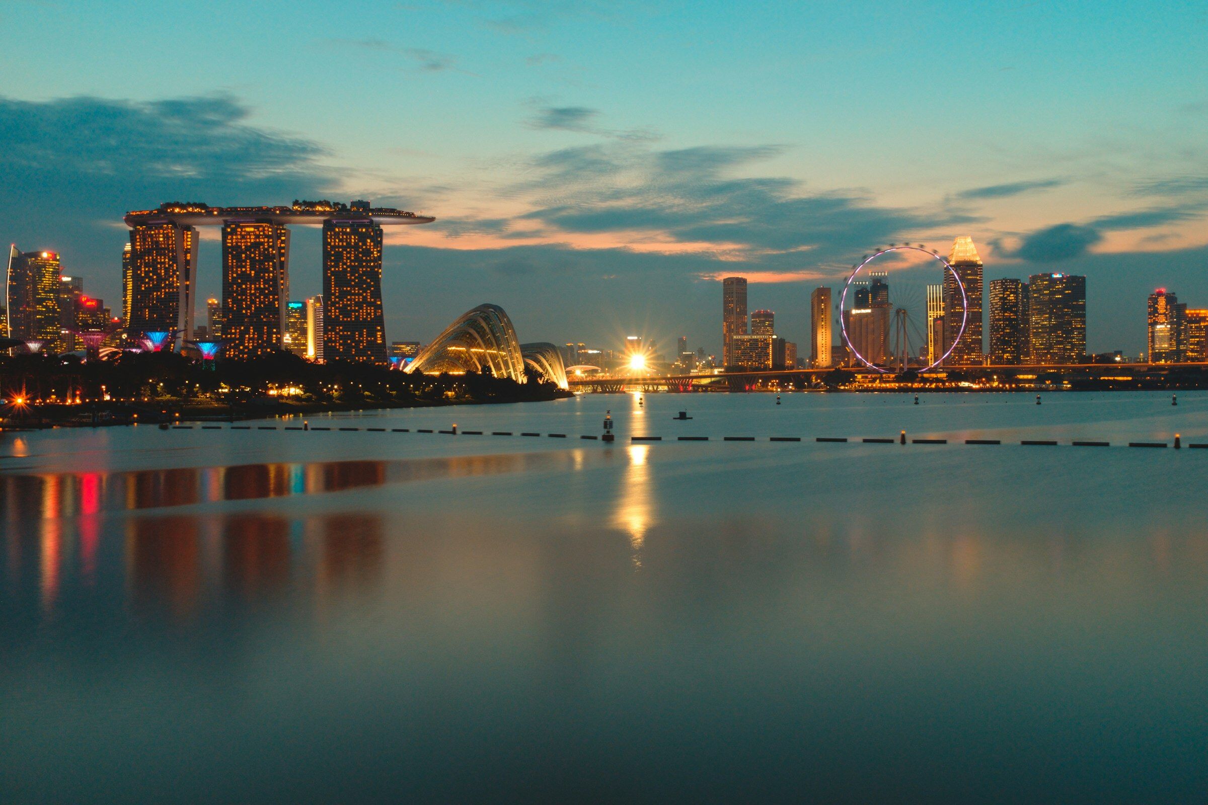 Singapore's Marina Bay skyline at dusk across calm water