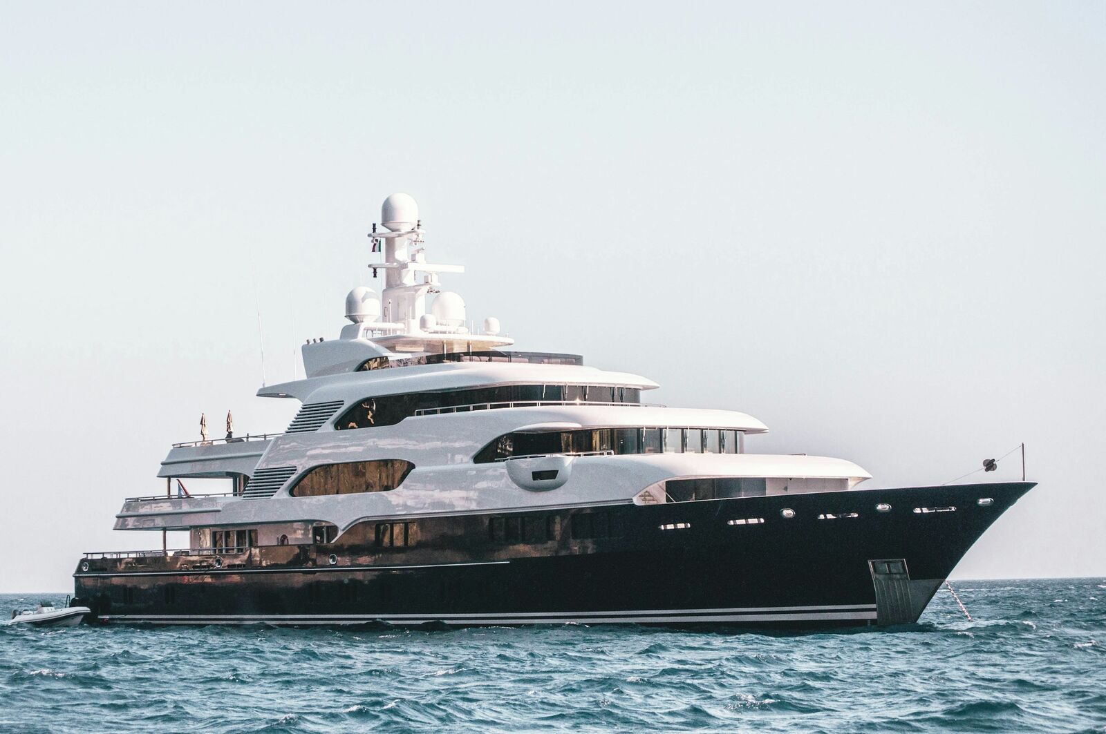 Profile of a superyacht with a dark hull and white superstructure